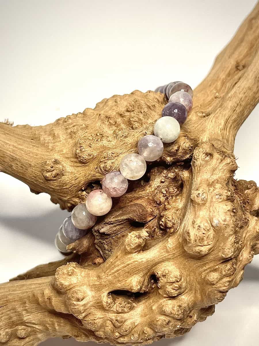 Bracelet en 6 mme en Tourmaline multi posé sur morceau de bois